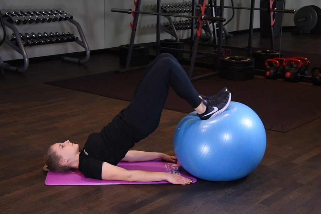 Prostowanie kolan z nogami na piłce do ćwiczeń Prostowanie kolan z nogami na piłce do ćwiczeń