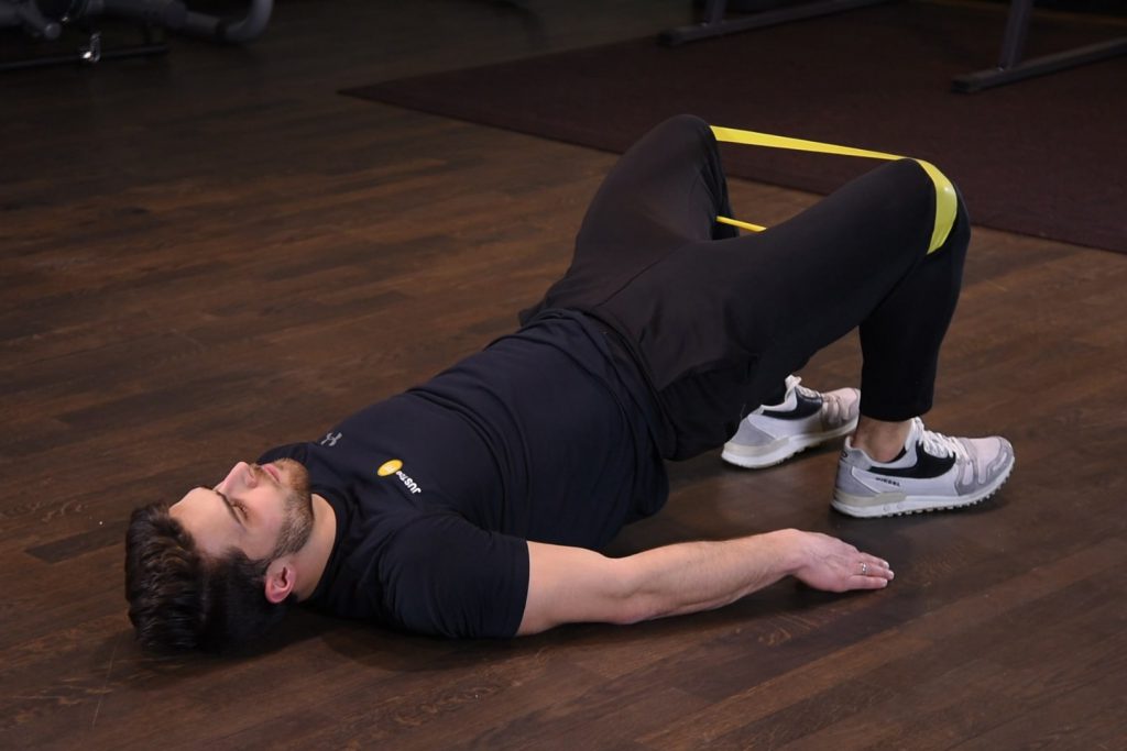 Odwodzenie kolan we wznosie bioder z gumą mini band na kolanach