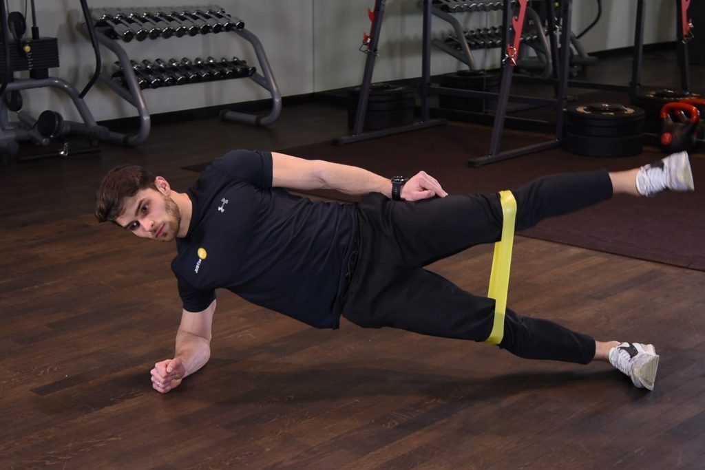 Odwodzenie nogi w planku bokiem z gumą mini band Odwodzenie nogi w planku bokiem z gumą mini band