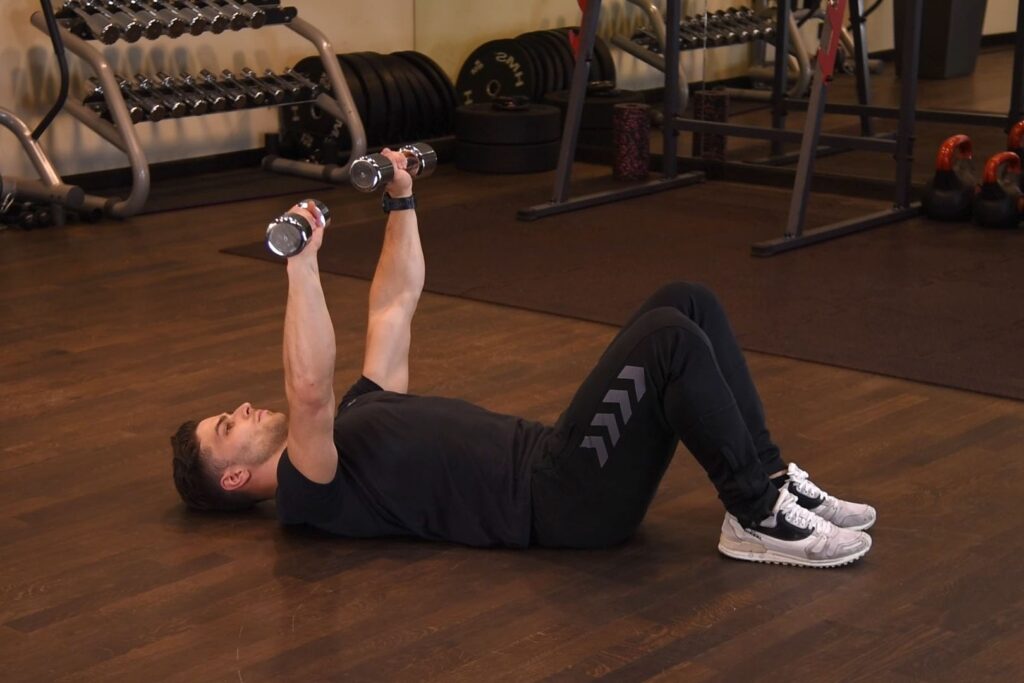 Wyciskanie hantli na ziemi szeroko